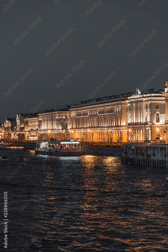 The formal architecture of St. Petersburg. The bridges and the river Neva embankment. Sunset over the city.