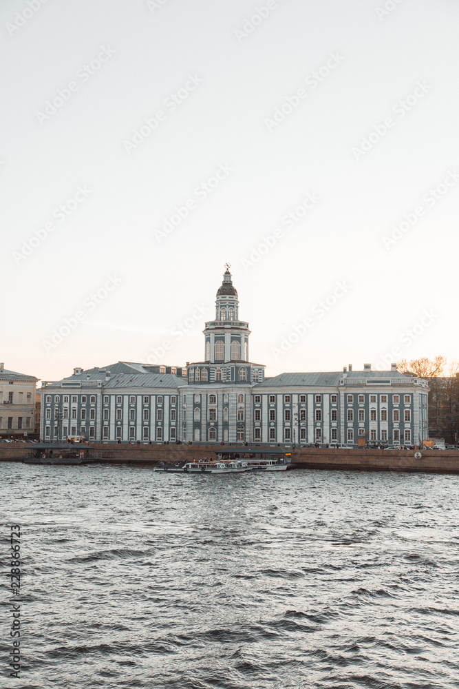 The formal architecture of St. Petersburg. The bridges and the river Neva embankment. Sunset over the city.