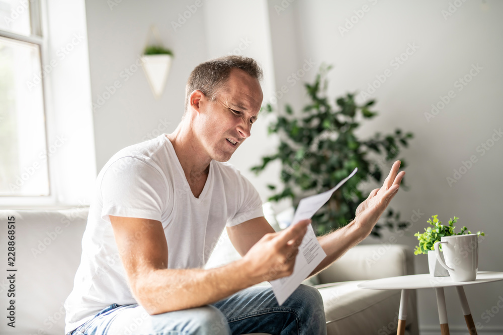 Bad news. Depressed mature man holding paper Bad news. Depressed mature man holding paper