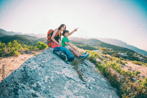 A woman with a child is sitting on top of a mountain.