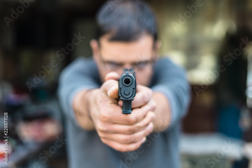 Close up on man pointing a gun to the camera