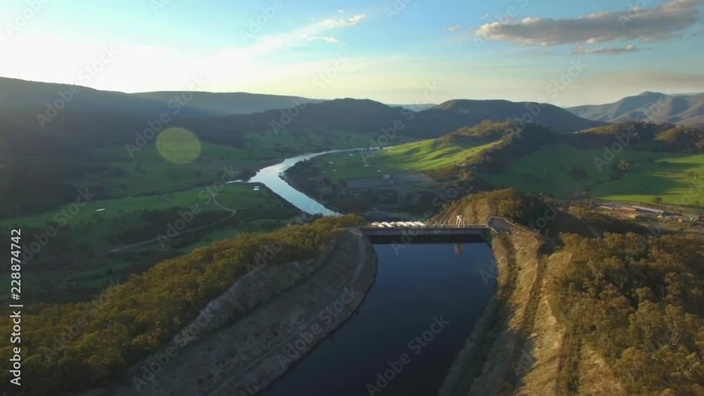 Backward flight over river and scenic mountains at sunset in New South Wales, Australia Backward flight over river and scenic mountains at sunset in New South Wales, Australia