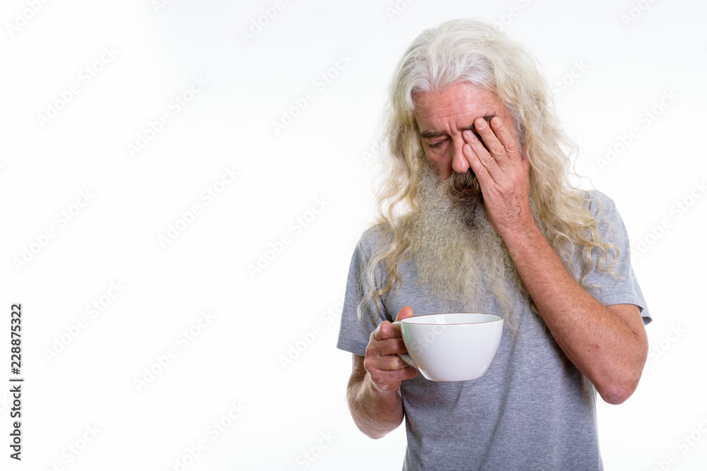 Studio shot of stressed senior bearded man covering face while h Studio shot of stressed senior bearded man covering face while h