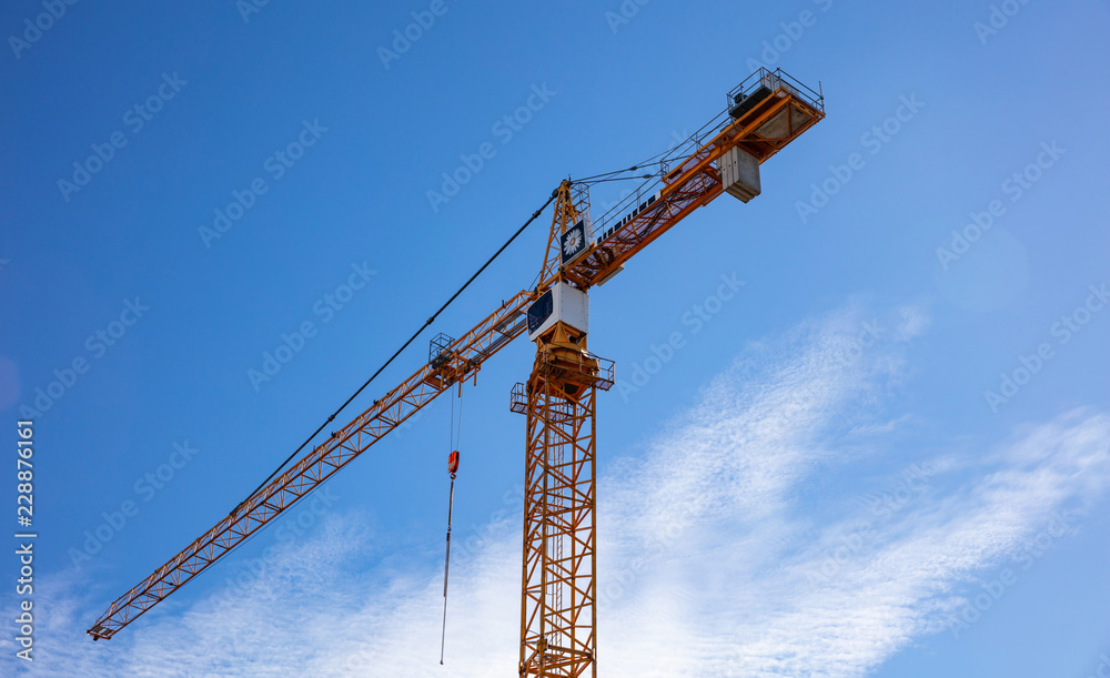 Red tower crane on blue sky background Red tower crane on blue sky background