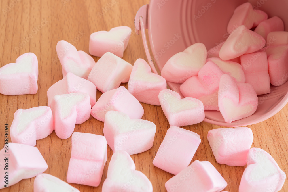 Fluffy pink heart marshmallow in small tank on table background Fluffy pink heart marshmallow in small tank on table background
