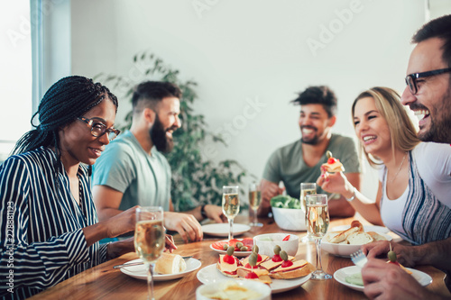 Group Of Happy Young Friends Enjoying Dinner At Home. Group of multiethnic friends enjoying dinner party
