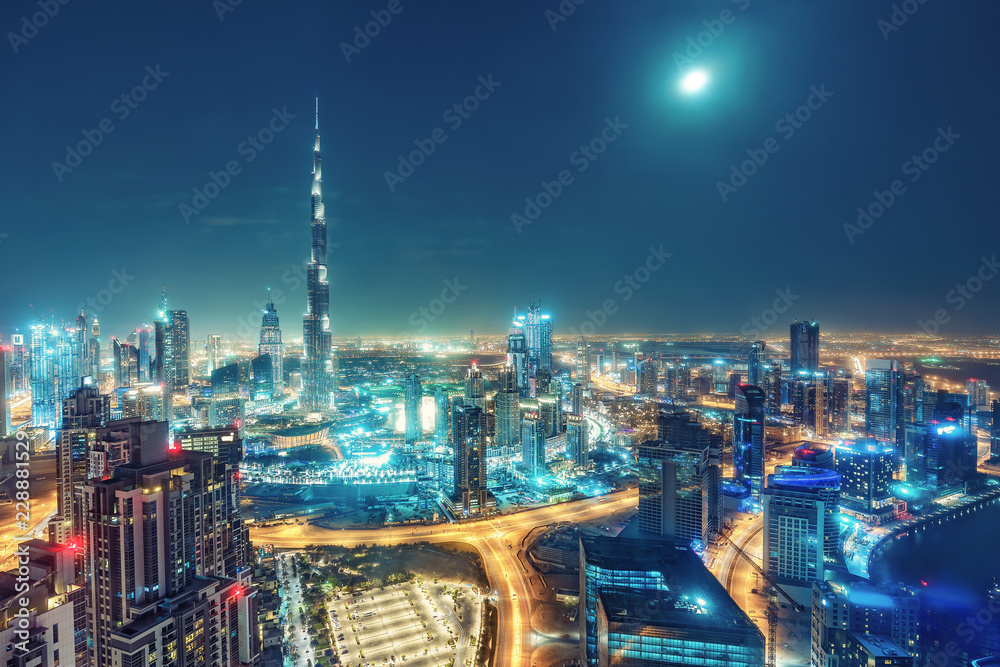 Aerial view on big futuristic city by night. Skyscrapers of Dubai, United Arab Emirates. Nighttime skyline.