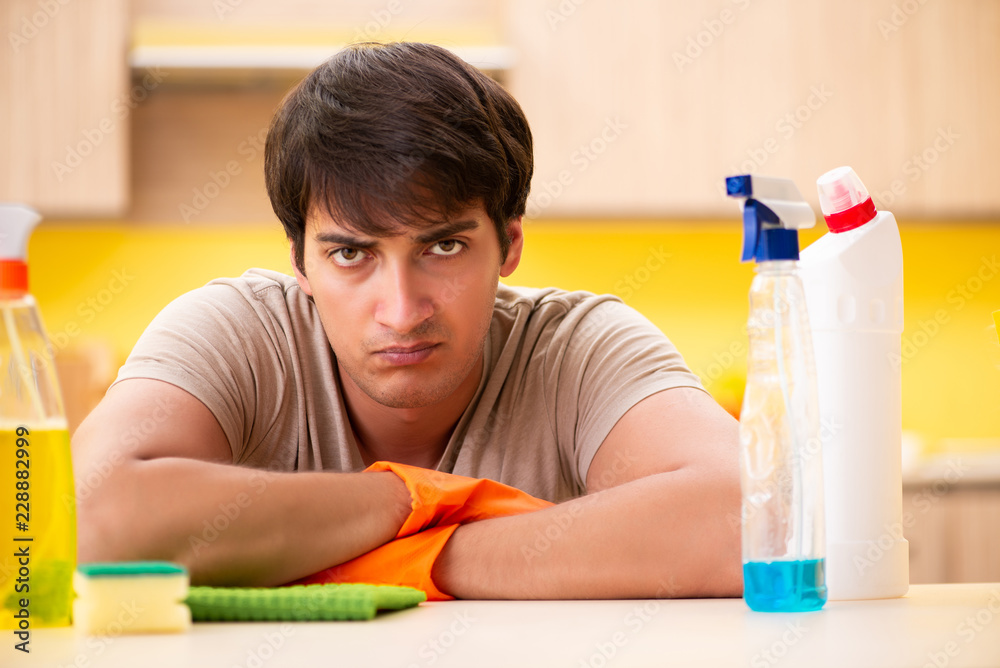 Single man cleaning kitchen at home Single man cleaning kitchen at home