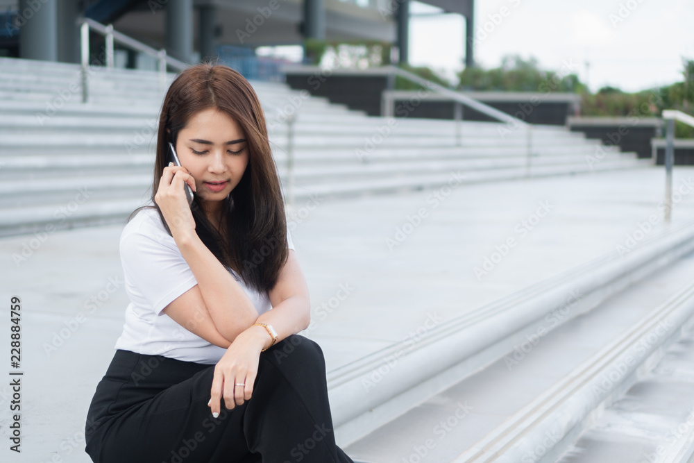 Young asian business woman in casual calling someone on phone and looking away. Young asian business woman in casual calling someone on phone and looking away.