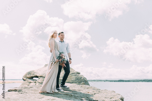 Weddings in the mountains by the rocks. The ceremony in the style of fine art. Summer walking photo shoot of newlyweds.