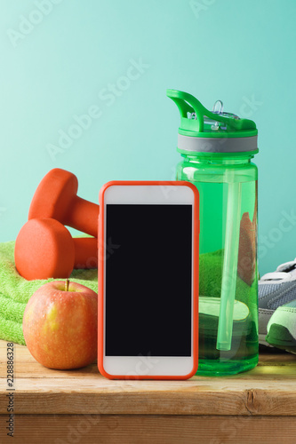 Fitness background with bottle of water, dumbbells and smart mobole phone photo