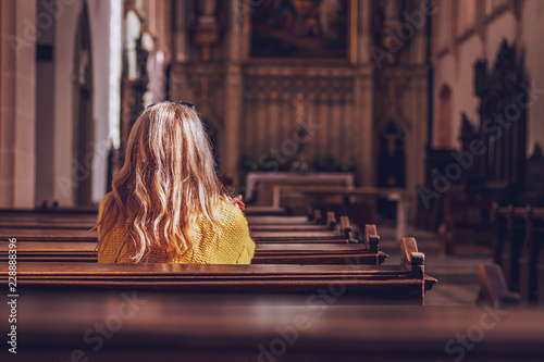 Young woman praying and meditating in church.  photo