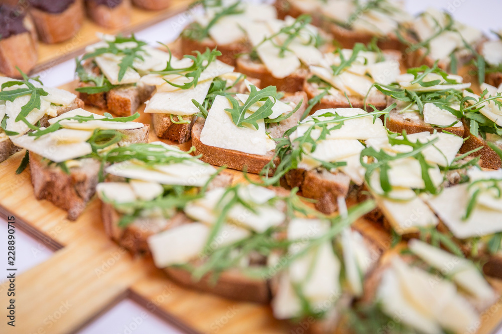 Catering / Belegte Brote mit Käse und Ruccola auf Holzbrett Catering / Belegte Brote mit Käse und Ruccola auf Holzbrett