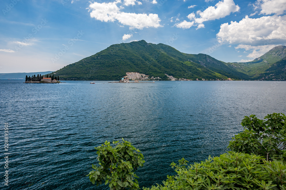 Sunny spring daytime view towards the two islets of Sv. Djordje, left and Gospa od Skrpjela, right also known as the church of Our Lady of the Rocks from the shore of Perast, Montenegro