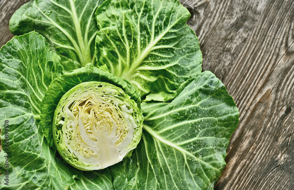 Obraz premium Colorful of cabbage cut half with water drop on wooden background.