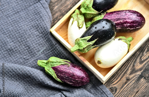 3 colorful mixed of Eggplant (Solanum melongena) or aubergine with water drop in wooden box on wooden background.