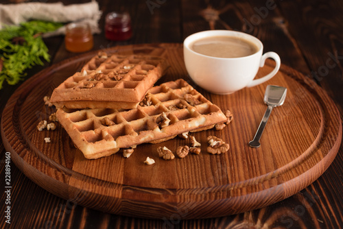 Tasty fresh Vienna wafers, jam and cup of coffee on a dark wooden background