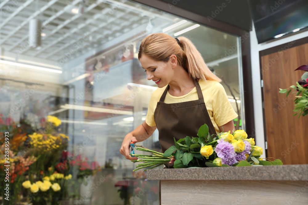 Female florist making beautiful bouquet in flower shop
