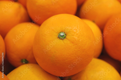 Closed up vibrant color fresh ripe mandarin orange on top of the pile 