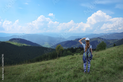 Woman with backpack in wilderness. Mountain landscape