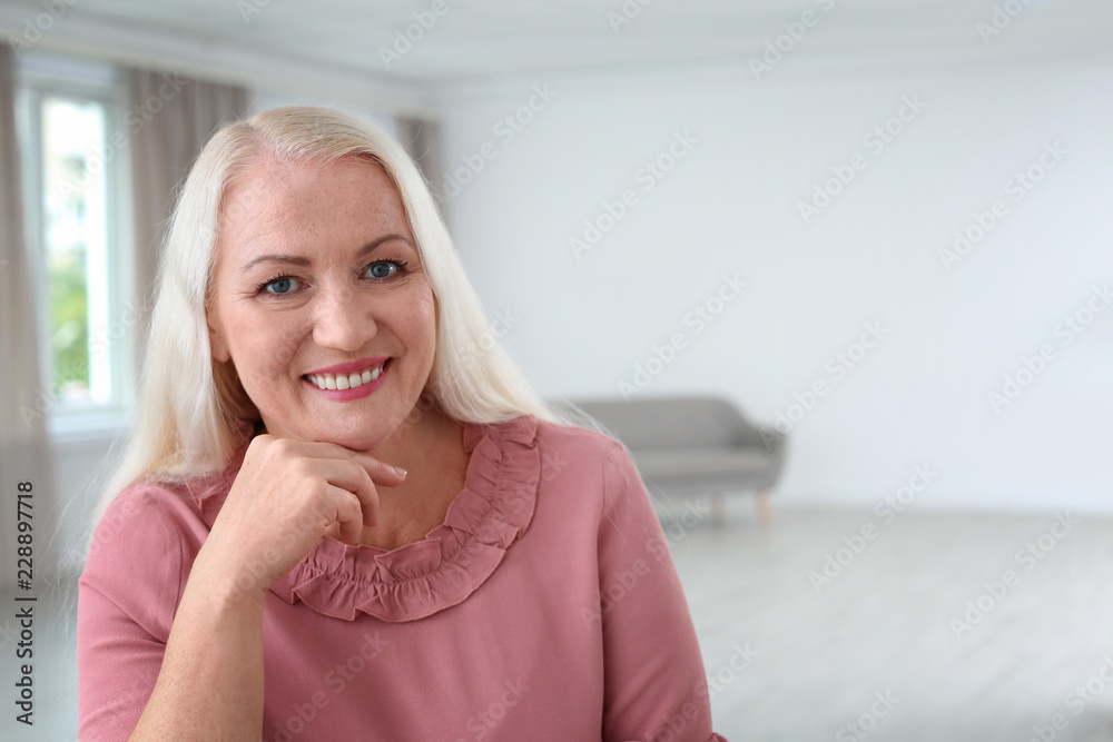 Portrait of beautiful older woman against blurred background with space for text Portrait of beautiful older woman against blurred background with space for text
