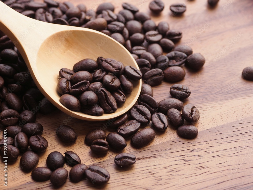 Top view Coffee beans in wooden spoon on wooden table background. Top view Coffee beans in wooden spoon on wooden table background.