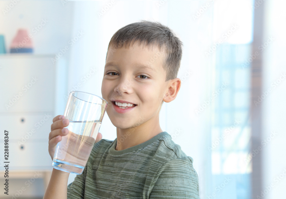 Little boy holding glass of fresh water indoors Little boy holding glass of fresh water indoors