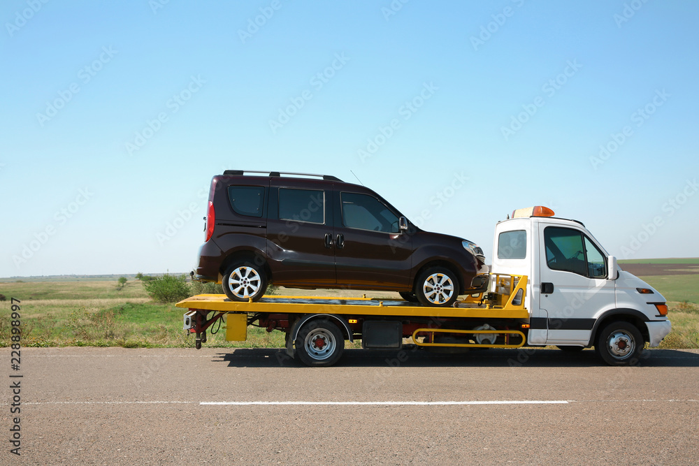 Tow truck with broken car on country road Tow truck with broken car on country road