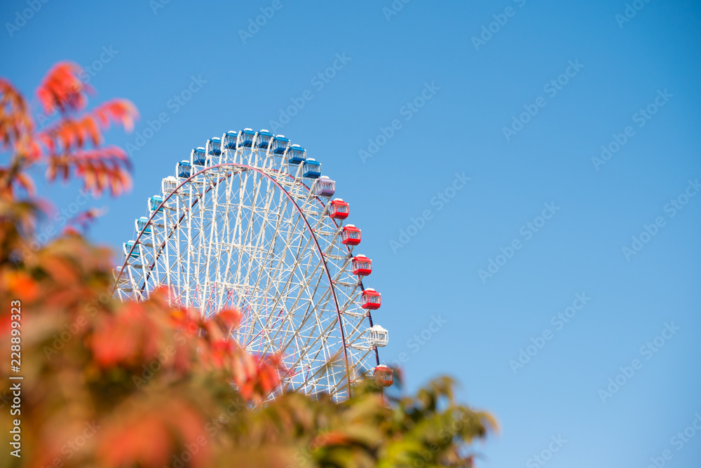 Giant ferris wheel on blue sky - Travel and recreation in amusement theme park holiday concept Giant ferris wheel on blue sky - Travel and recreation in amusement theme park holiday concept