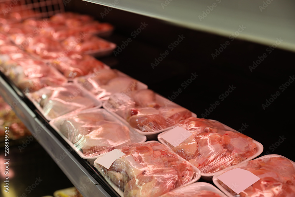 Shelf with packed chicken meat in supermarket Shelf with packed chicken meat in supermarket