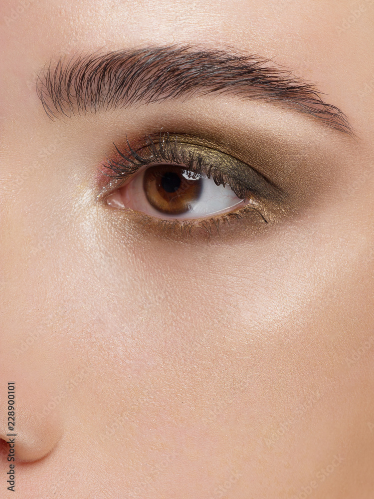 Macro shot. Close-up beauty of woman's eye. Sexy smoky eyes makeup with brown eyeshadows. Perfect strong shape of eyebrows. Make-up and Cosmetics Macro shot. Close-up beauty of woman's eye. Sexy smoky eyes makeup with brown eyeshadows. Perfect strong shape of eyebrows. Make-up and Cosmetics