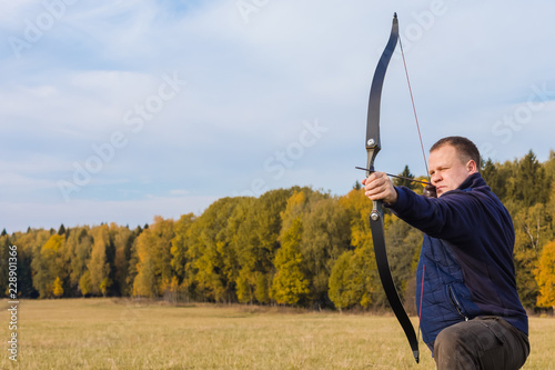 Athlete aiming at a target and shoots an arrow. Archery