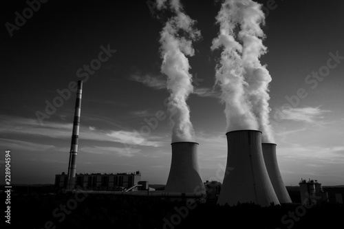 A Power plant with white smoke over it’s chimneys