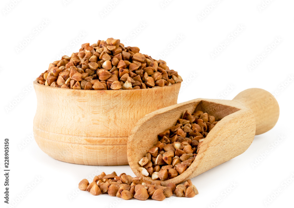 Buckwheat in wooden plate and spoon close-up. Isolated. Buckwheat in wooden plate and spoon close-up. Isolated.