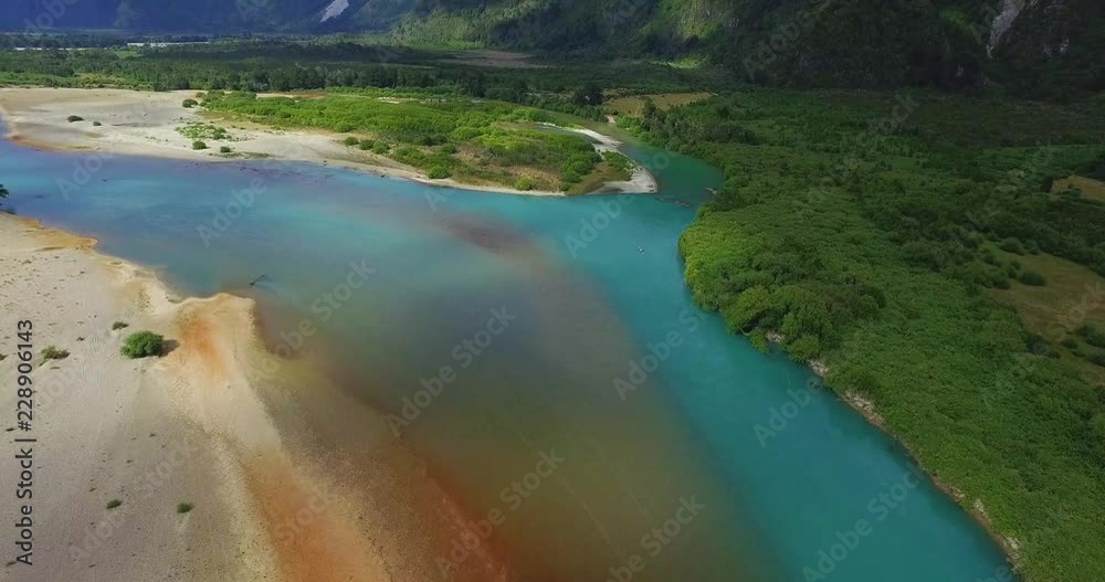 Aerial view of the Puelo River and its turquoise water, the landscape is surrounded by native forest and mountains Aerial view of the Puelo River and its turquoise water, the landscape is surrounded by native forest and mountains