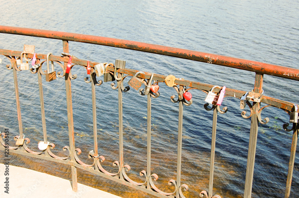 Locks of happy couples hung on the railing of the embankment fence.