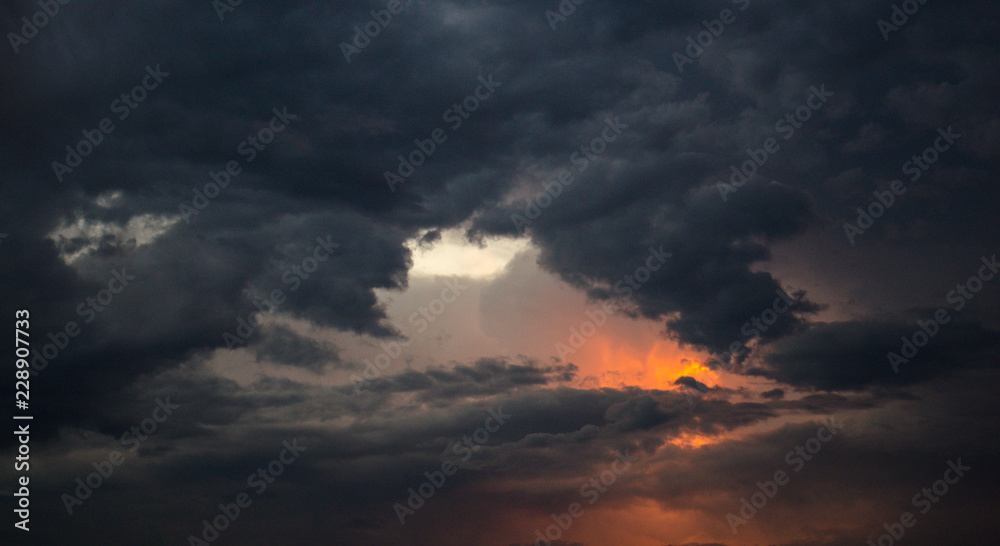 Dramatic dark rain storm clouds sky at sunset bad weather thunderstorm summer storm