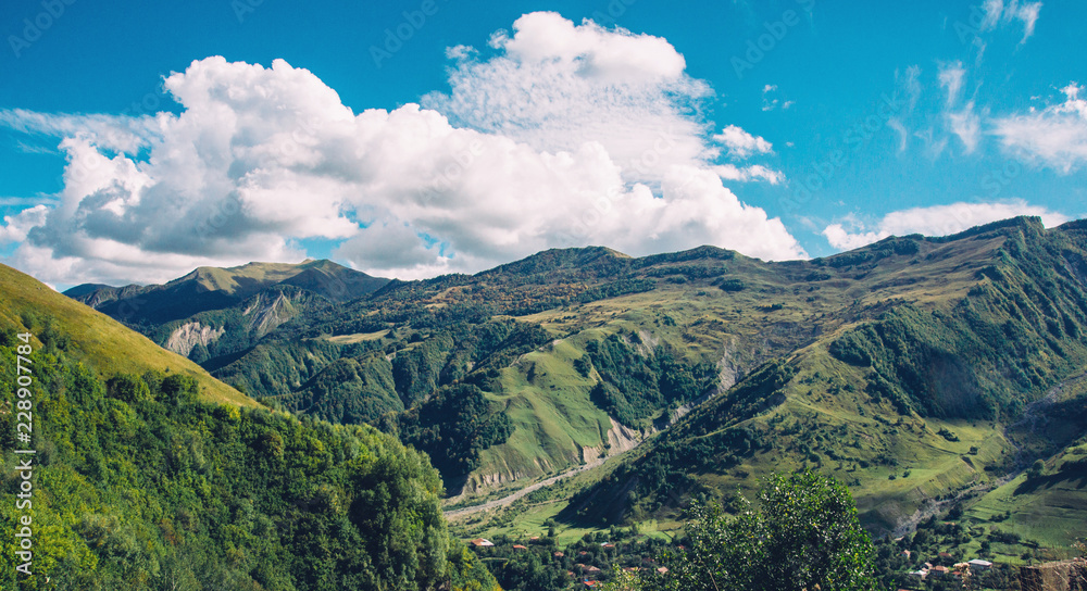 Mountain hill path road panoramic landscape, clouds in the blue sky, summer sunny day