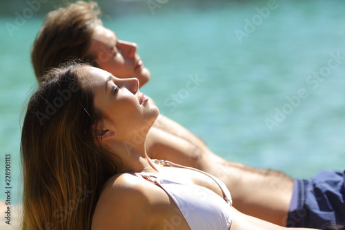 Relaxed couple sunbathing on the beach on vacation