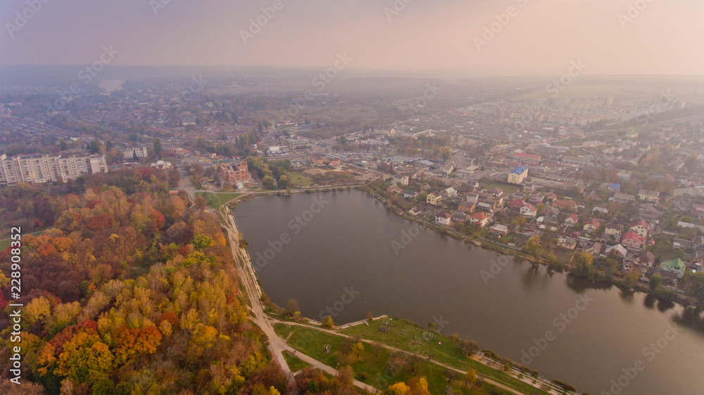 Aerial view of the autumn city park near the lake. Beautiful view of nature.