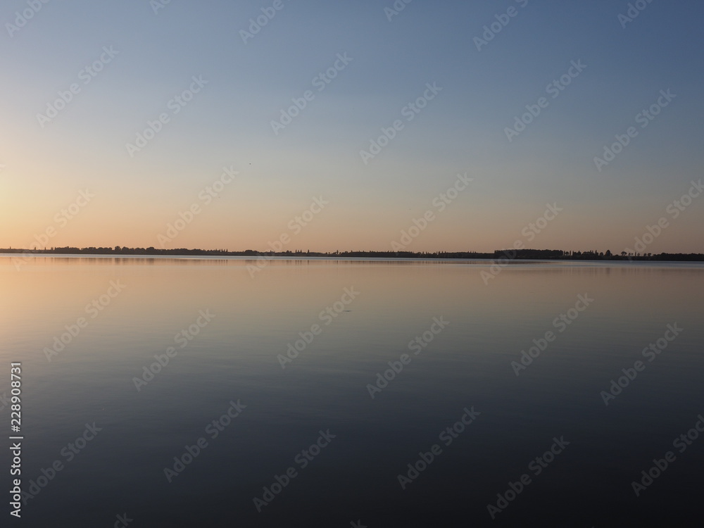 Amazing sun set over artificial european Goczalkowice Reservoir in Poland with beauty blue sky on landscape