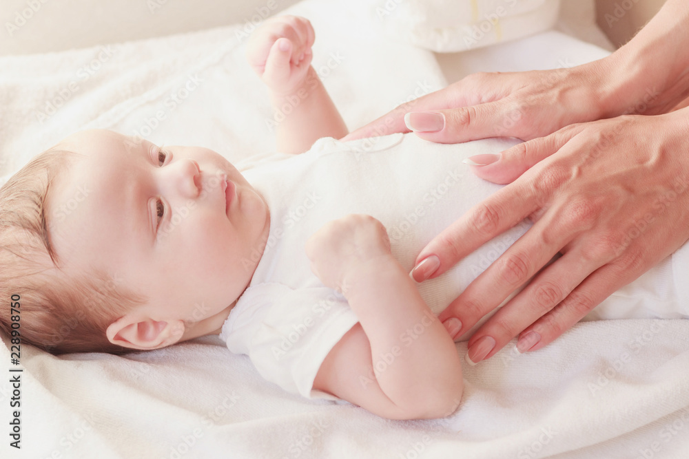 Baby and hands of mother, soft focus background Baby and hands of mother, soft focus background