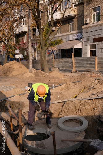 The builder looks into the well, repairs a septic tank