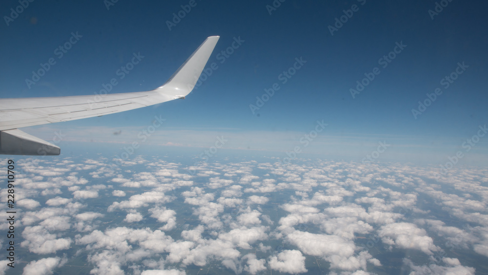 wing of an airplane flying above the clouds wing of an airplane flying above the clouds
