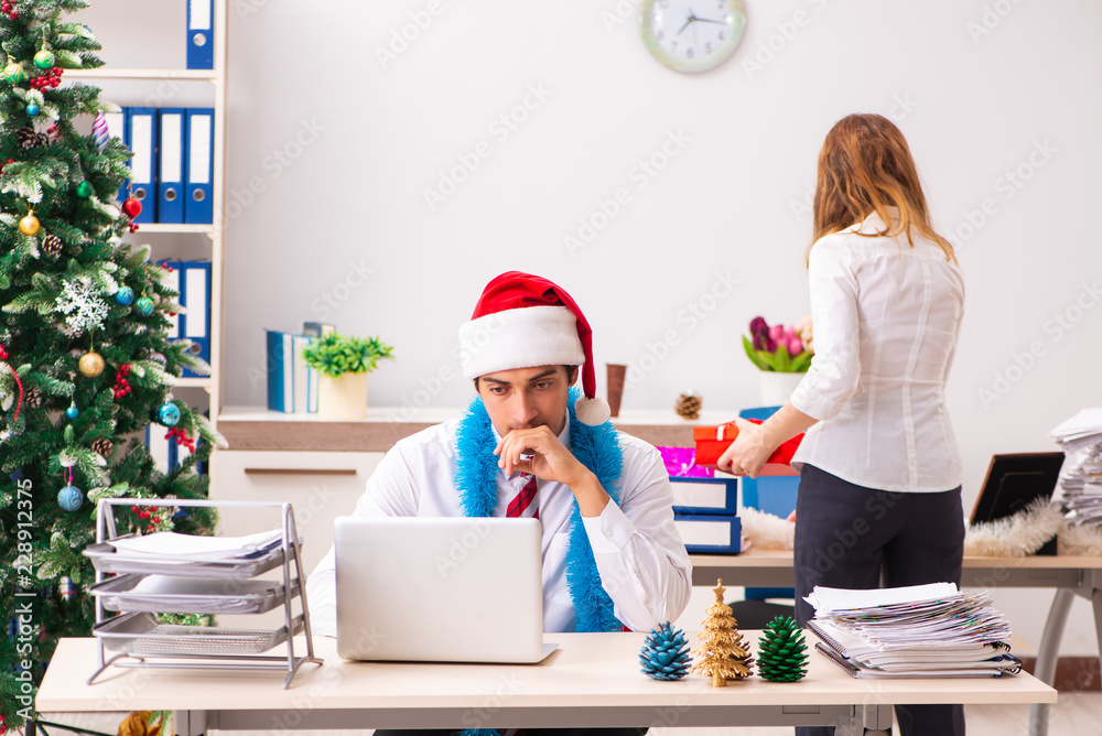 Man and woman working at the office on Cristmass eve Man and woman working at the office on Cristmass eve