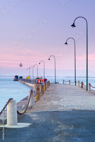 Fototapeta Naklejka Na Ścianę i Meble -  pink sunset above pier with street lighters