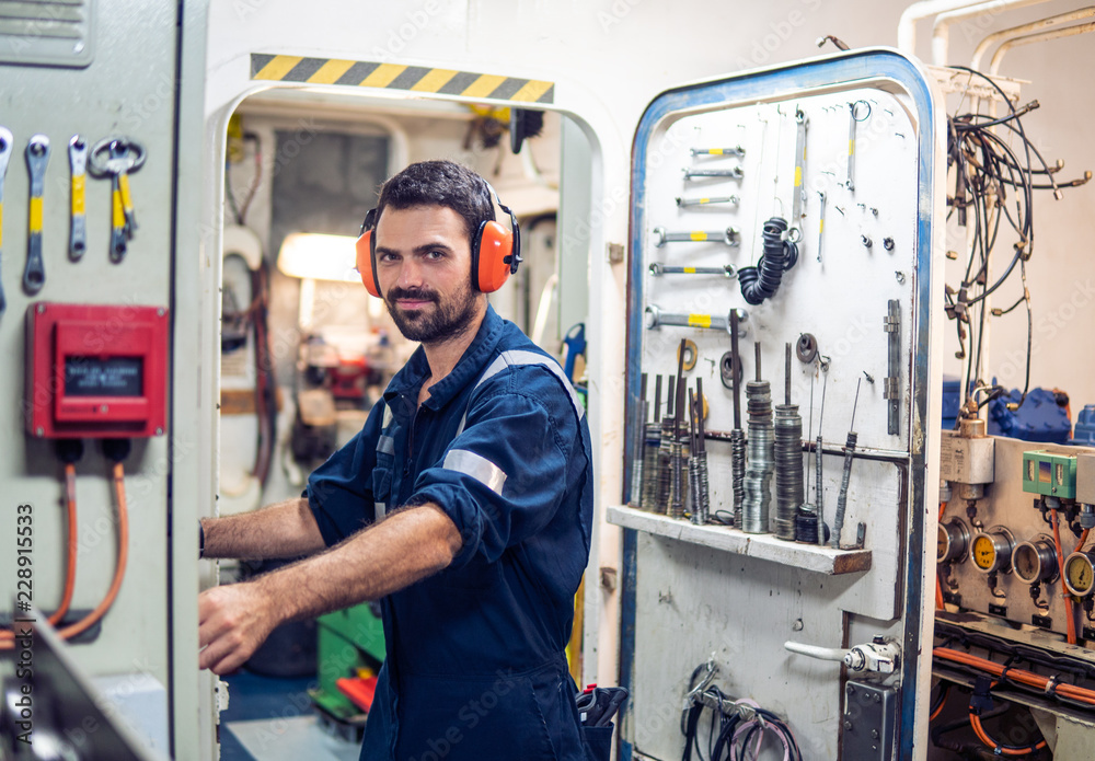 Marine engineer officer in engine control room ECR. Seamen's work. He starts or stops main engine of ship Marine engineer officer in engine control room ECR. Seamen's work. He starts or stops main engine of ship