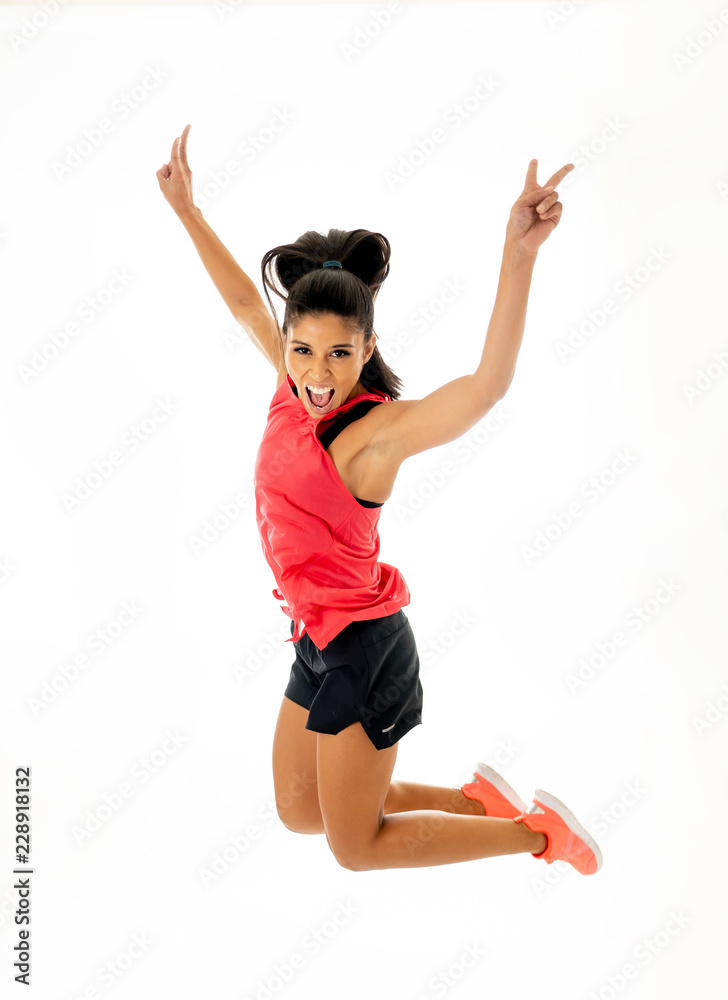 Attractive excited fitness modern dancer girl in sport wear jumping of joy dancing and working out