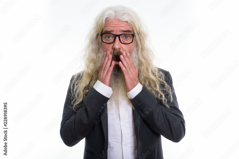 Studio shot of senior bearded businessman looking shocked while Studio shot of senior bearded businessman looking shocked while