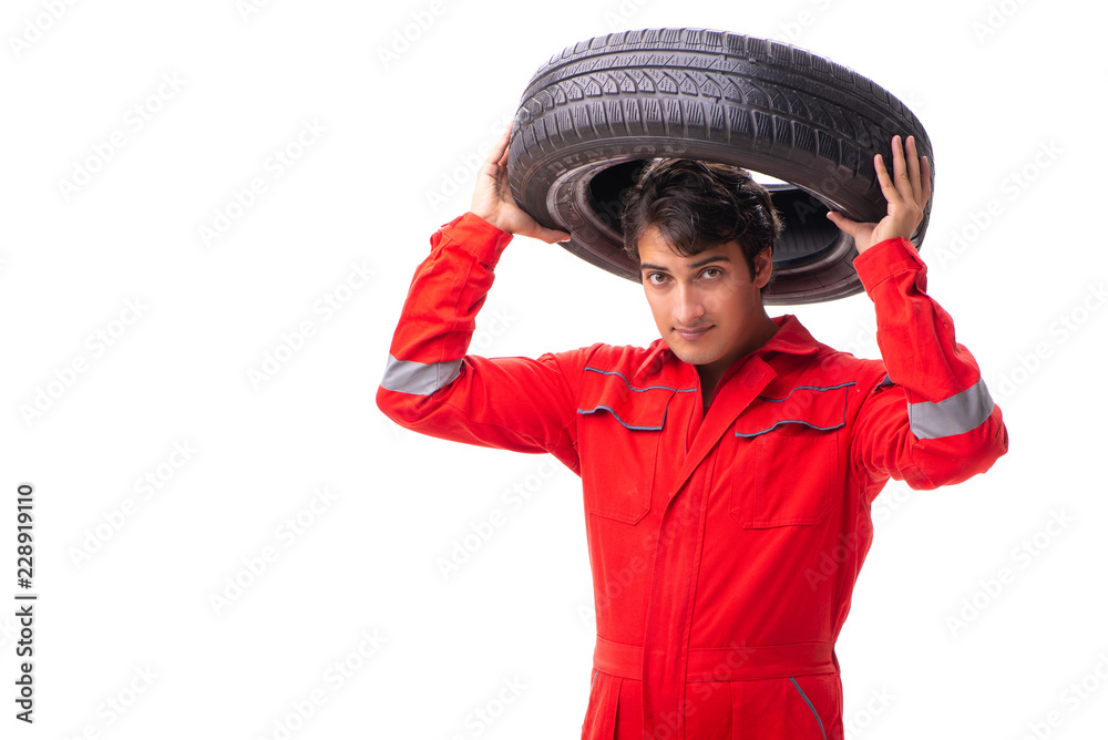 Young garage worker with tyre isolated on white Young garage worker with tyre isolated on white